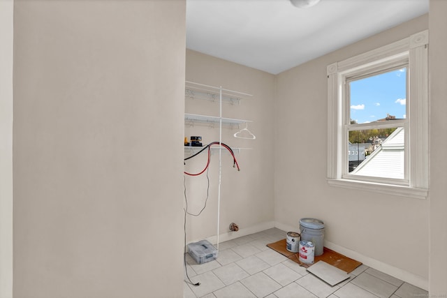 clothes washing area with light tile patterned flooring, baseboards, washer hookup, and a healthy amount of sunlight