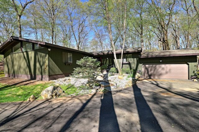 mid-century modern home with driveway and a garage