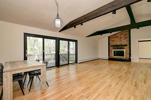 dining room with a fireplace, baseboard heating, vaulted ceiling with beams, light wood-type flooring, and rail lighting