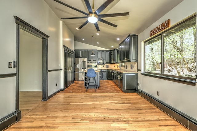 kitchen featuring ceiling fan, light wood-style flooring, stainless steel appliances, a baseboard radiator, and a kitchen island