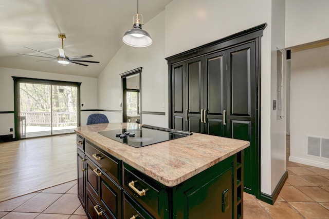 kitchen featuring a kitchen island, light tile patterned flooring, black electric stovetop, and visible vents