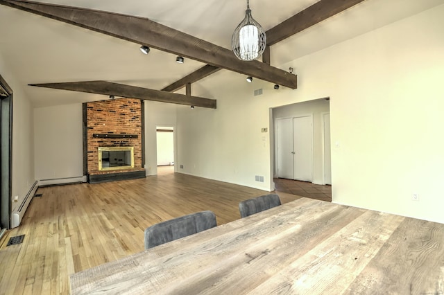 unfurnished living room featuring visible vents, lofted ceiling with beams, a baseboard heating unit, and wood finished floors