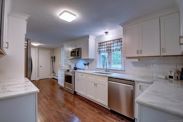 267 Foote Rd, Glastonbury, CT 06073 - kitchen with appliances with stainless steel finishes, a sink, dark wood-style floors, tasteful backsplash, and white cabinets