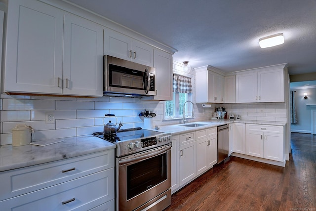 267 Foote Rd, Glastonbury, CT 06073 - kitchen featuring appliances with stainless steel finishes, a sink, white cabinets, backsplash, and a textured ceiling