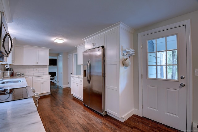 267 Foote Rd, Glastonbury, CT 06073 - kitchen featuring stainless steel fridge, black microwave, white cabinetry, backsplash, and dark wood-style flooring