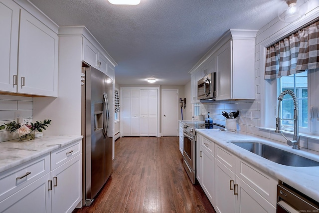 267 Foote Rd, Glastonbury, CT 06073 - kitchen featuring appliances with stainless steel finishes, a sink, dark wood finished floors, white cabinetry, and tasteful backsplash