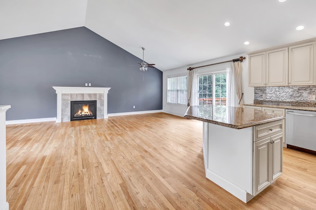kitchen featuring a fireplace, ceiling fan, light wood-type flooring, a center island, and dishwasher