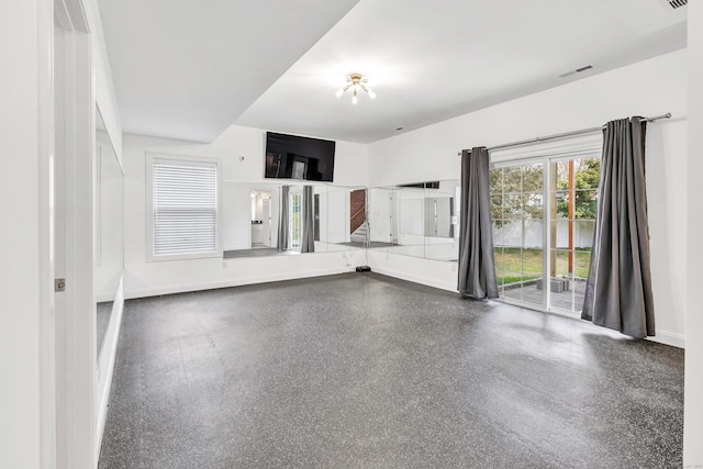 unfurnished living room with baseboards and visible vents