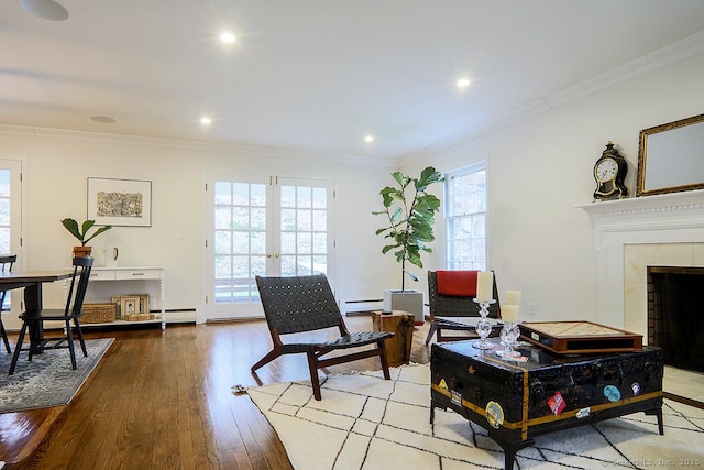 living area featuring wood-type flooring, recessed lighting, crown molding, and baseboard heating