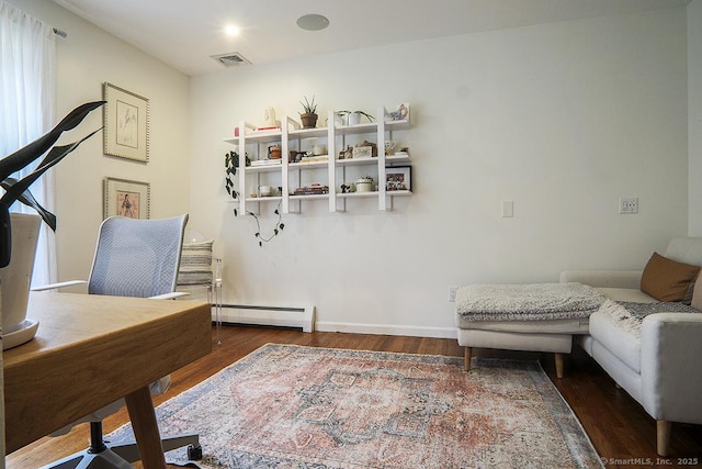 interior space with plenty of natural light, a baseboard heating unit, wood finished floors, and visible vents