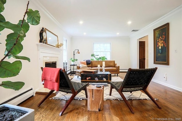 living area with crown molding, visible vents, a fireplace, wood finished floors, and a baseboard heating unit
