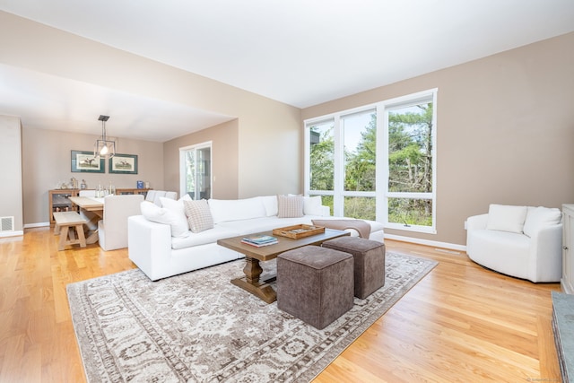 living room with baseboards, light wood-style flooring, and visible vents