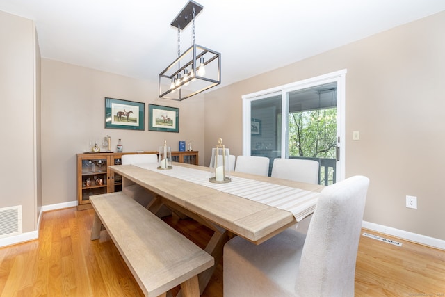 dining space with baseboards, visible vents, and light wood-style floors
