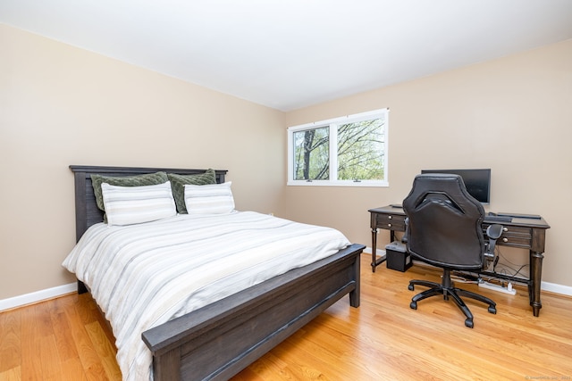 bedroom with baseboards and light wood-style flooring