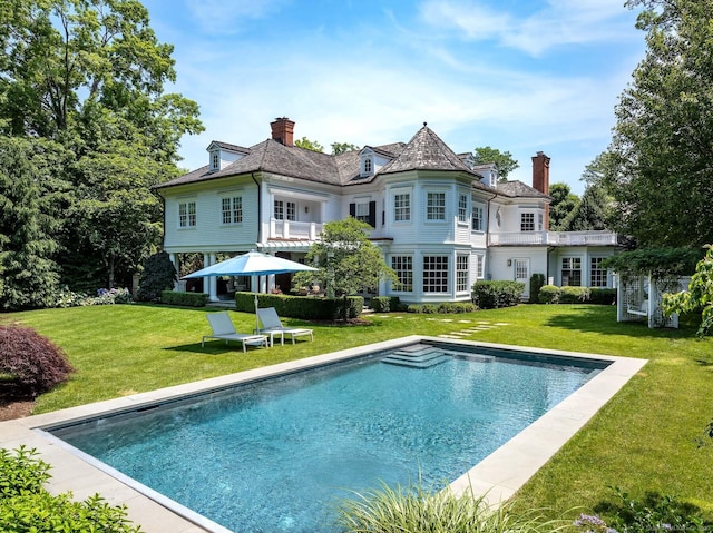35 Club Rd, Greenwich, CT 06878 - rear view of house featuring a yard, an outdoor pool, a balcony, and a chimney