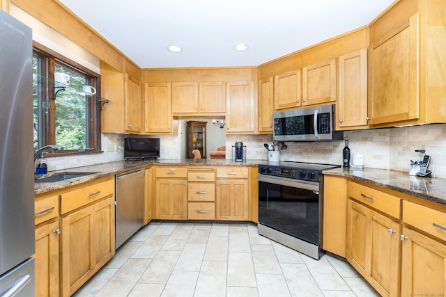 kitchen featuring light tile patterned flooring, a sink, stainless steel appliances, recessed lighting, and decorative backsplash