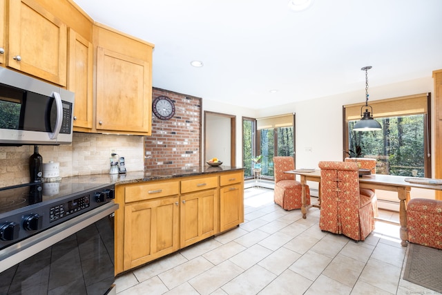 kitchen with decorative backsplash, black electric range, hanging light fixtures, light tile patterned floors, and stainless steel microwave