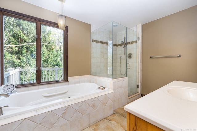 full bathroom with tile patterned floors, a sink, a garden tub, and a stall shower