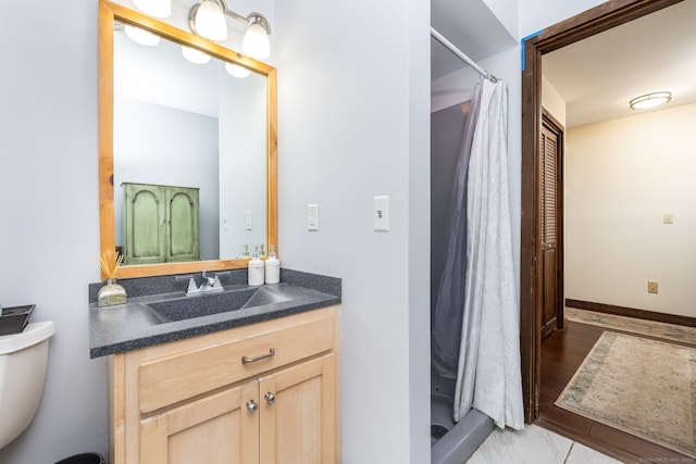 bathroom with toilet, baseboards, a shower with shower curtain, and vanity