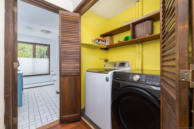 laundry area with laundry area, a baseboard radiator, independent washer and dryer, and visible vents