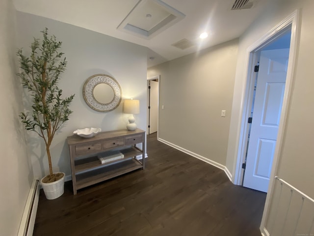 corridor with baseboards, visible vents, dark wood-style floors, and a baseboard radiator