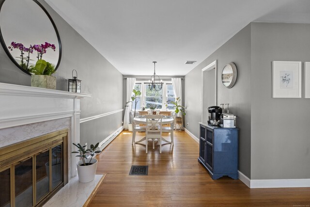 131 Vesper St, Fairfield, CT 06825 - dining space featuring visible vents, a baseboard radiator, wood finished floors, and an inviting chandelier