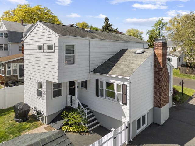131 Vesper St, Fairfield, CT 06825 - exterior space featuring roof with shingles, a chimney, and fence private yard