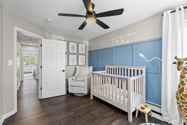 131 Vesper St, Fairfield, CT 06825 - bedroom with dark wood-style flooring, a crib, a decorative wall, a ceiling fan, and a baseboard radiator