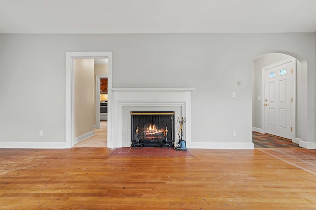 240 Barbara Rd, Middletown, CT 06457 - unfurnished living room with arched walkways, wood finished floors, and a fireplace with flush hearth
