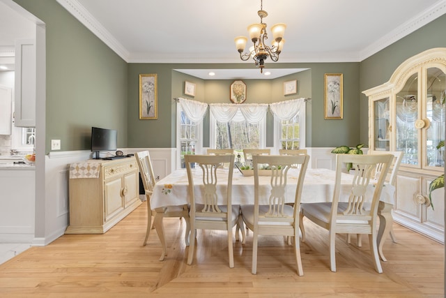 dining room featuring a chandelier, light wood-style floors, and crown molding