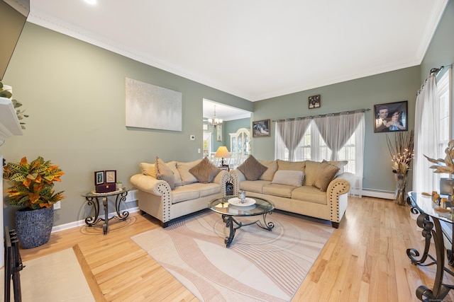 living area with a notable chandelier, a wealth of natural light, wood finished floors, and a baseboard radiator