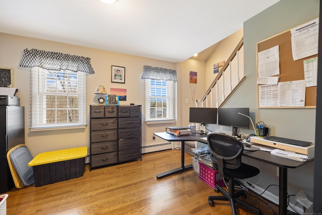 office with wood finished floors and a baseboard heating unit