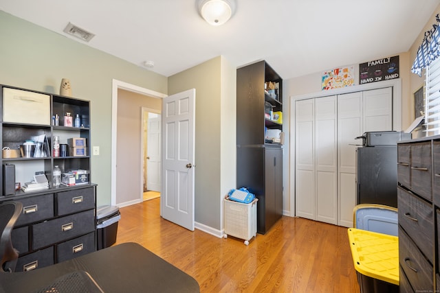 office area featuring baseboards, visible vents, and light wood-type flooring