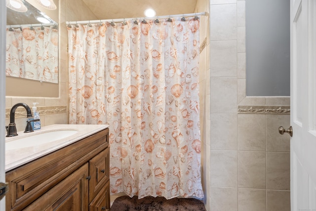 full bathroom with tile walls, curtained shower, and vanity