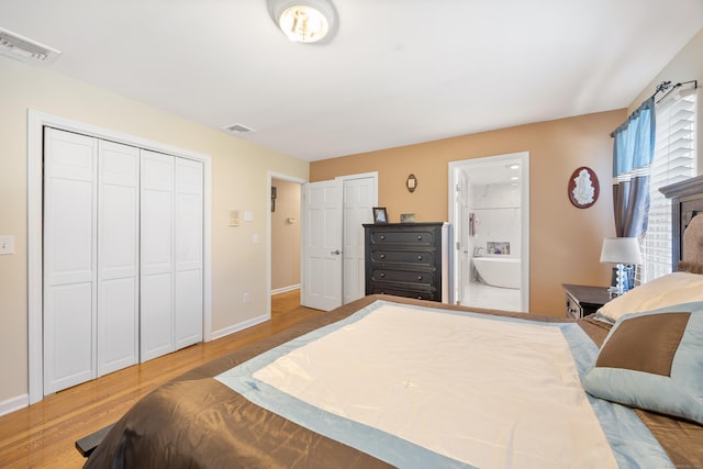 bedroom featuring visible vents, wood finished floors, two closets, and baseboards