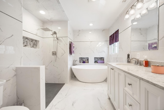bathroom with marble finish floor, toilet, vanity, a soaking tub, and a marble finish shower