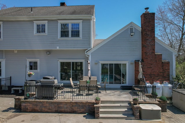 rear view of house with a chimney and a patio area
