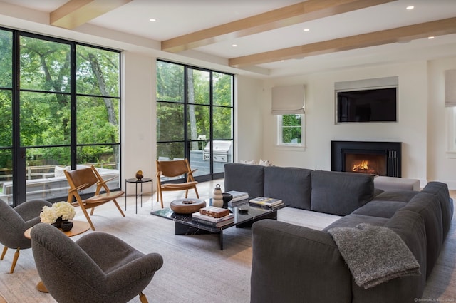 living room with a lit fireplace, recessed lighting, and beam ceiling
