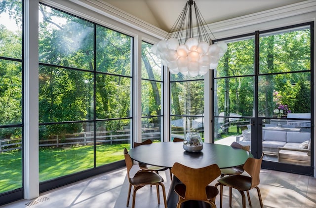 sunroom / solarium with visible vents, a chandelier, and vaulted ceiling