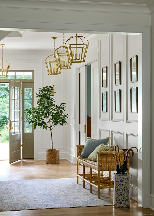 interior space featuring an inviting chandelier, wood finished floors, and a decorative wall
