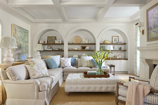 living area with crown molding, beamed ceiling, built in shelves, and coffered ceiling
