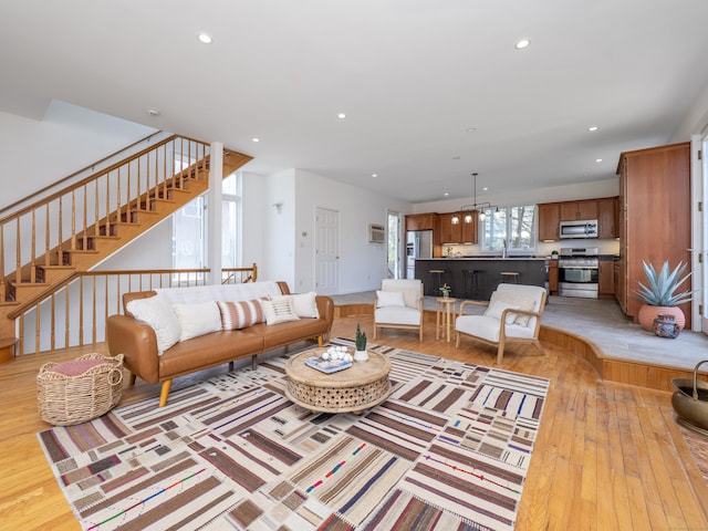 living area featuring recessed lighting, stairway, and light wood-type flooring