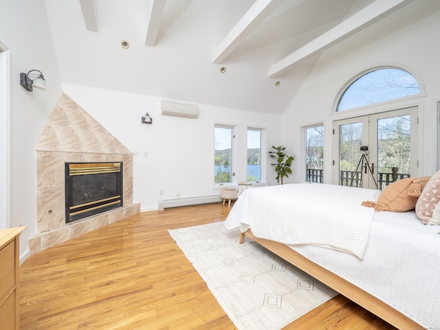 bedroom featuring beamed ceiling, baseboard heating, an AC wall unit, a fireplace, and access to outside