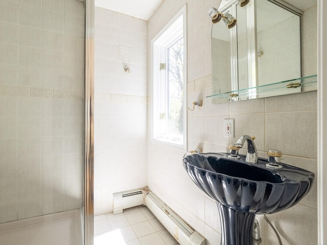bathroom with a baseboard heating unit, a stall shower, and tile walls