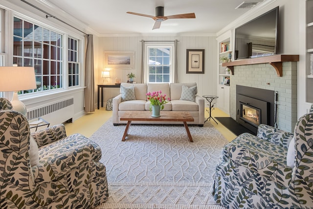 living room featuring crown molding, a ceiling fan, radiator, and visible vents