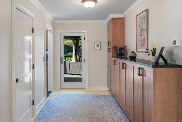 doorway to outside featuring baseboards, ornamental molding, and light carpet