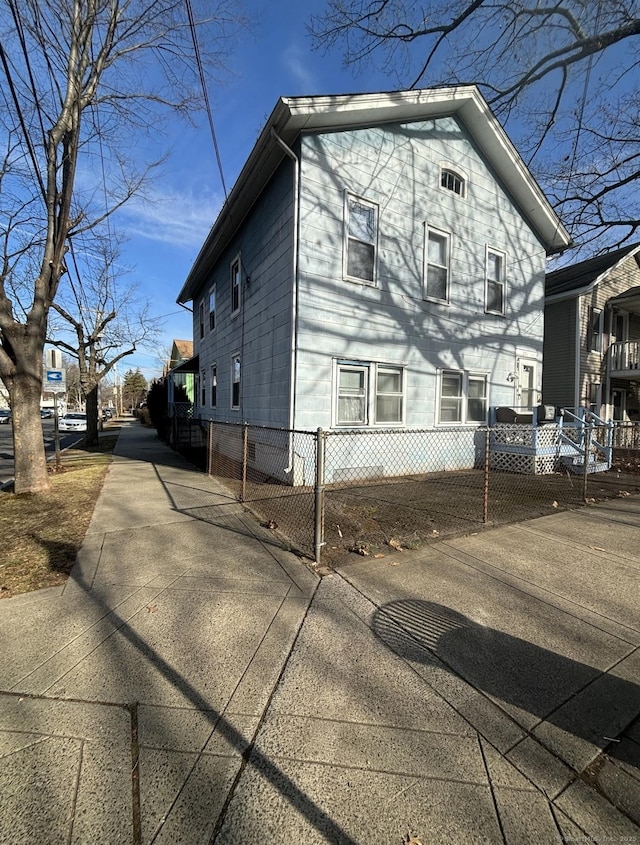 view of property exterior with driveway and a fenced front yard