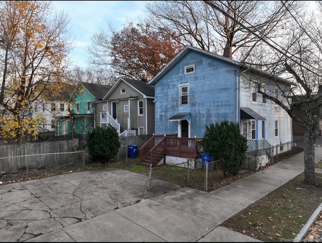 view of front of property featuring a deck, a chimney, and fence