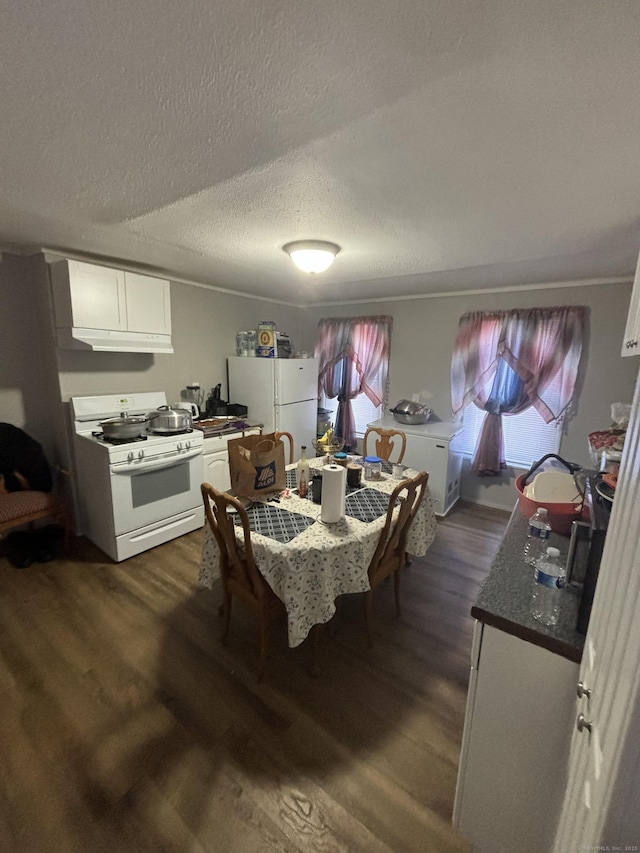 dining space with a textured ceiling and dark wood finished floors