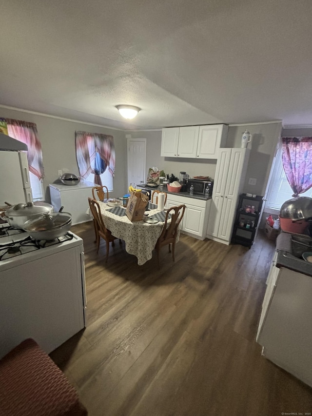 dining space with dark wood-type flooring and a textured ceiling